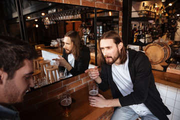 Side view of drunk friends sitting near the mirror