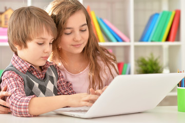 Boy and girl using laptop