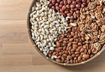 Different nuts in old wooden dish