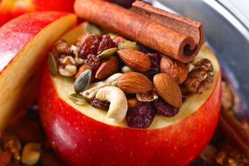 Red juicy apple with assorted nuts , raisins and cinnamon