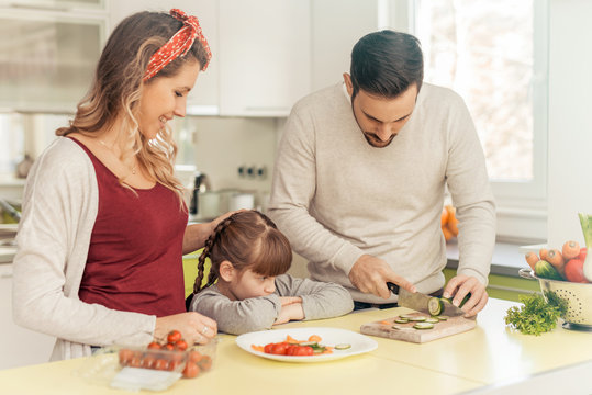 Happy young family preparing lunch