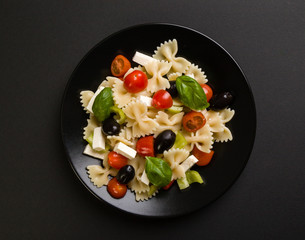 farfalle salad on black plate