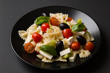 farfalle salad on black plate