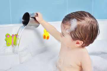 small child takes a bath with foam