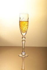 Glass of sparkling shampagne wine on gold background