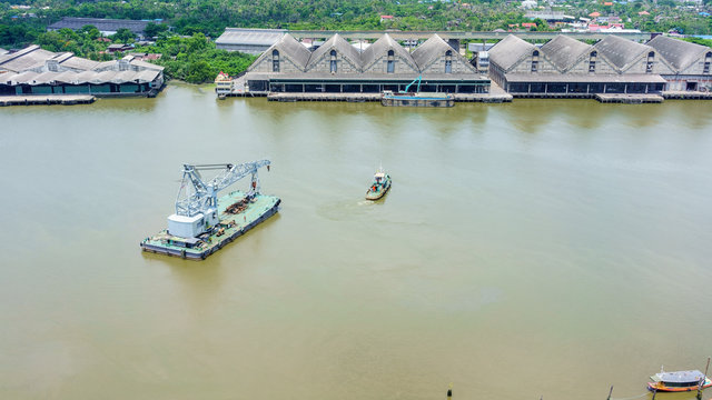 River tugboat turning and towing ship in Chao Phraya river , Bangkok , Thailand