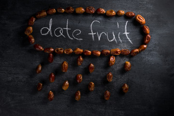 Date fruit over dark chalkboard background
