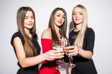 Three young women cheers, celebrating and drinking champagne on the party