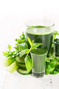 Healthy green smoothie in a glass with vegetables.