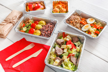 Healthy food take away in boxes, top view at wood