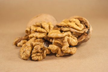 Walnut kernels and whole walnuts on kraft paper, close up, horiz