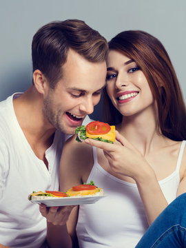 Couple Eating Crispbread With Cheese And Tomato