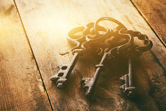 close up of vintage skeleton keys over wooden table