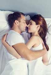 Young couple sleeping and hugging on the bed in bedroom