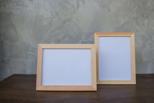 Two photo Frame on a wooden on Gray wall background .