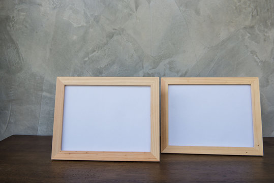 Two photo Frame on a wooden on Gray wall background .