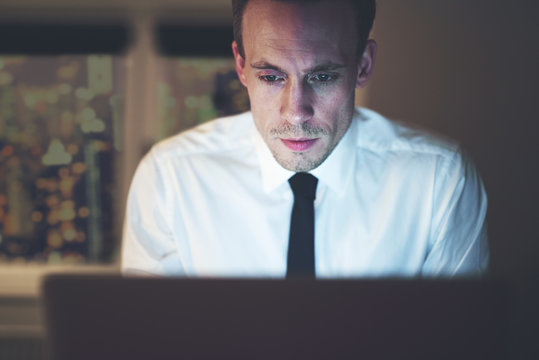 Close up of businessman working overtime on computer