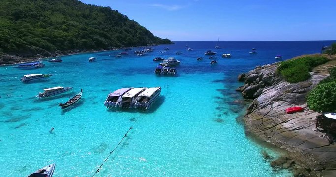 Racha Island Beach. Thailand, Phuket. Yachts , Catamarans and Boats sailing in crrystal clear blue water of ocean. Flying from beach to ocean. Aerial view. 4K.