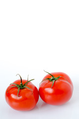 Two tomatoes on a white background