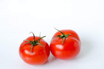 Two tomatoes on a white background