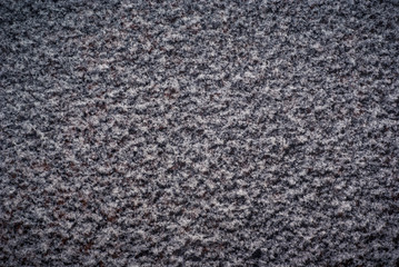 A thin layer of snow on the granite slab