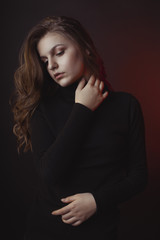 Tender young woman with lush hair posing in sweater