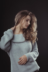 Fototapeta premium Sensual blonde woman posing in knitted sweater. Studio shot