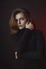 Wonderful young woman posing in sweater in the shadows