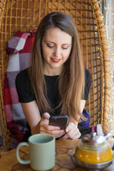 young woman in a cafe looking at smartphone