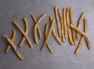 grissini, italian bread sticks, spreaded on gray background