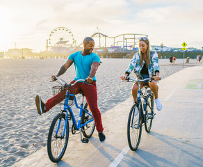 couple having fun riding bikes together at santa monica california - Powered by Adobe