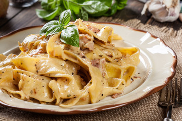 Pappardelle pasta with prosciutto and cheese sauce on a plate