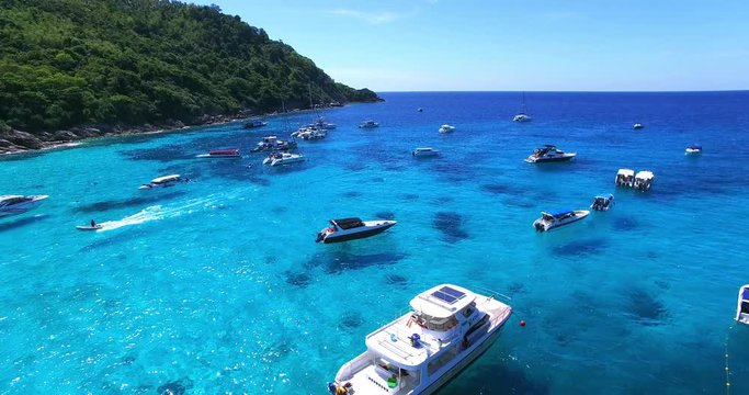 Racha Island Beach. Thailand, Phuket. Yachts , Catamarans and Boats sailing in crrystal clear blue water of ocean. Flying from beach to ocean. Aerial view. 4K.