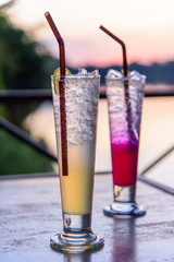 cocktail in the glass with sunset view / beverage with sunset at the lake view