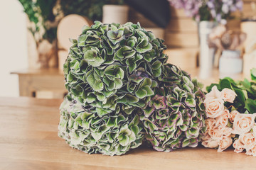 Flower shop background. Green flowers and roses for bouquet delivery