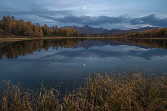 Mirror Surface Lake Autumn Landscape With Mountain Range And Moon On Background