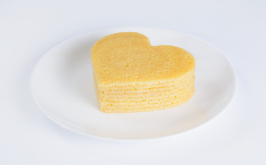 Pile of pancakes in the shape of a heart on plate