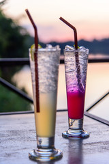 cocktail in the glass with sunset view / beverage with sunset at the lake view