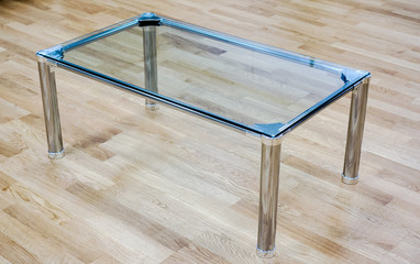 Clear glass small table against wooden floor on office reception