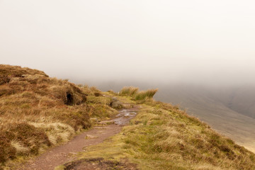 The Path Along the Escarpment. A public walking path goes along the escarpment of Craig y Fan Ddu in the Brecon Beacon National Park taking no notice of the long drop to the valley below.