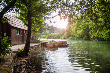 Wooden boat at the pier on the beautiful clear lake in the woods