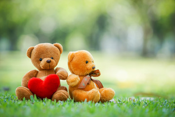 two bear dolls and red heart on the ground , select focus the one bigger