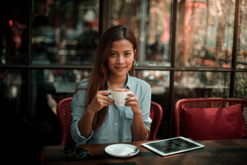 Asian woman drinking coffee in vintage color tone