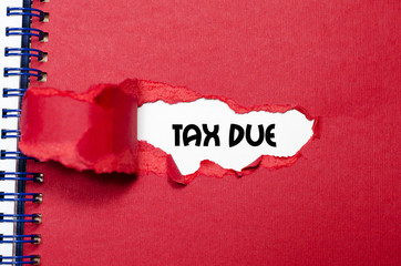 The word tax due appearing behind torn paper
