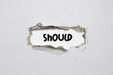 The word should appearing behind torn paper