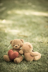 two bear dolls and red heart with dramatic tone , select focus the one bigger