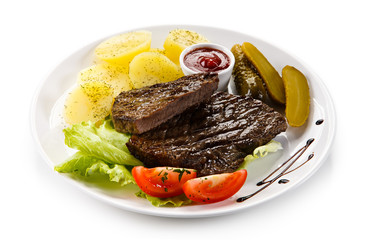 Grilled steaks, French fries and vegetables 