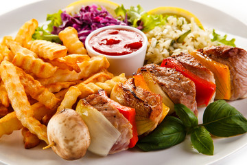 Kebabs - grilled meat and vegetables on white background 