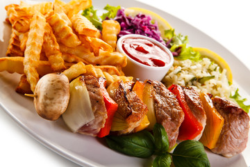 Kebabs - grilled meat and vegetables on white background 