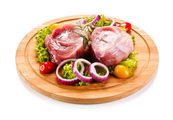Fototapeta premium Raw meat on cutting board and vegetables 